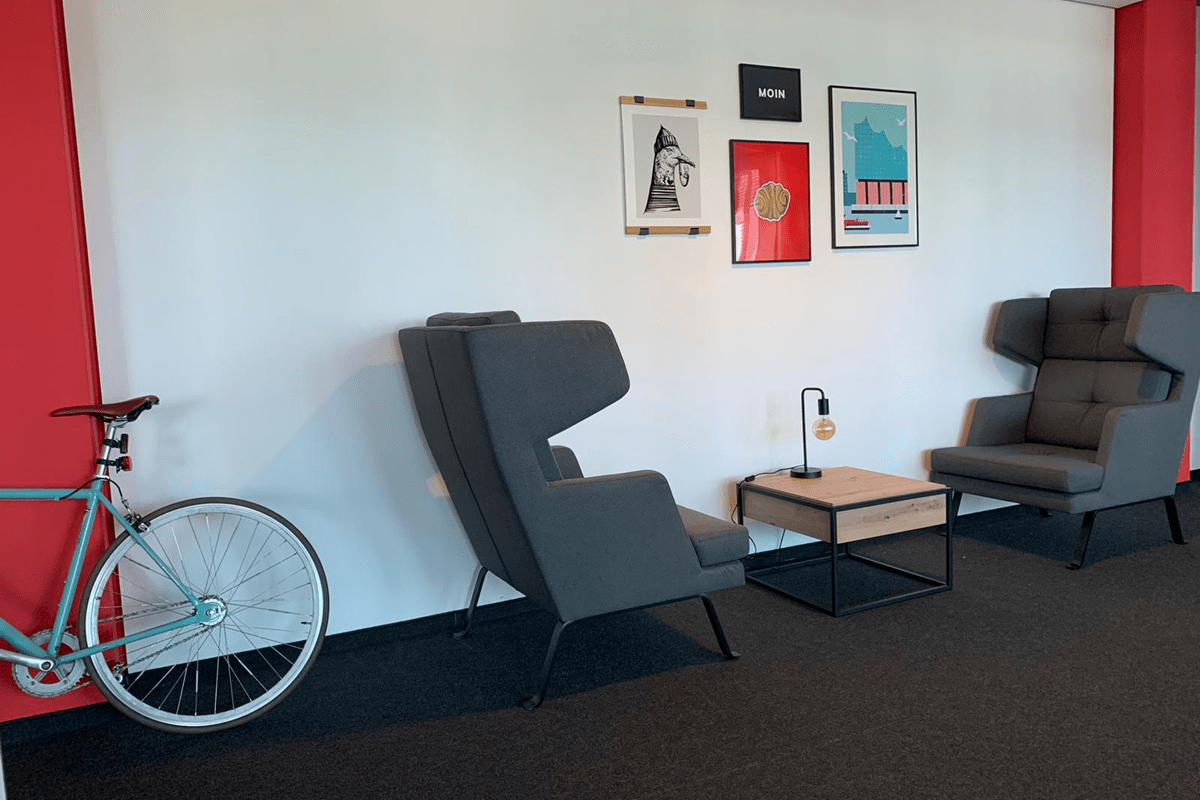 Two Chairs in our Hamburg Office a blue Bike on the side and pictures on the wall 