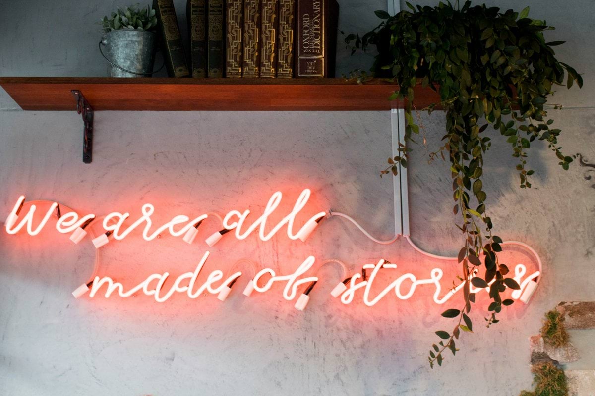 lighted we are all made of stories red neon wall signage inside room
