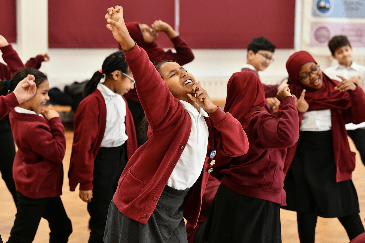 A group of school children take part in a theatrical workshop.