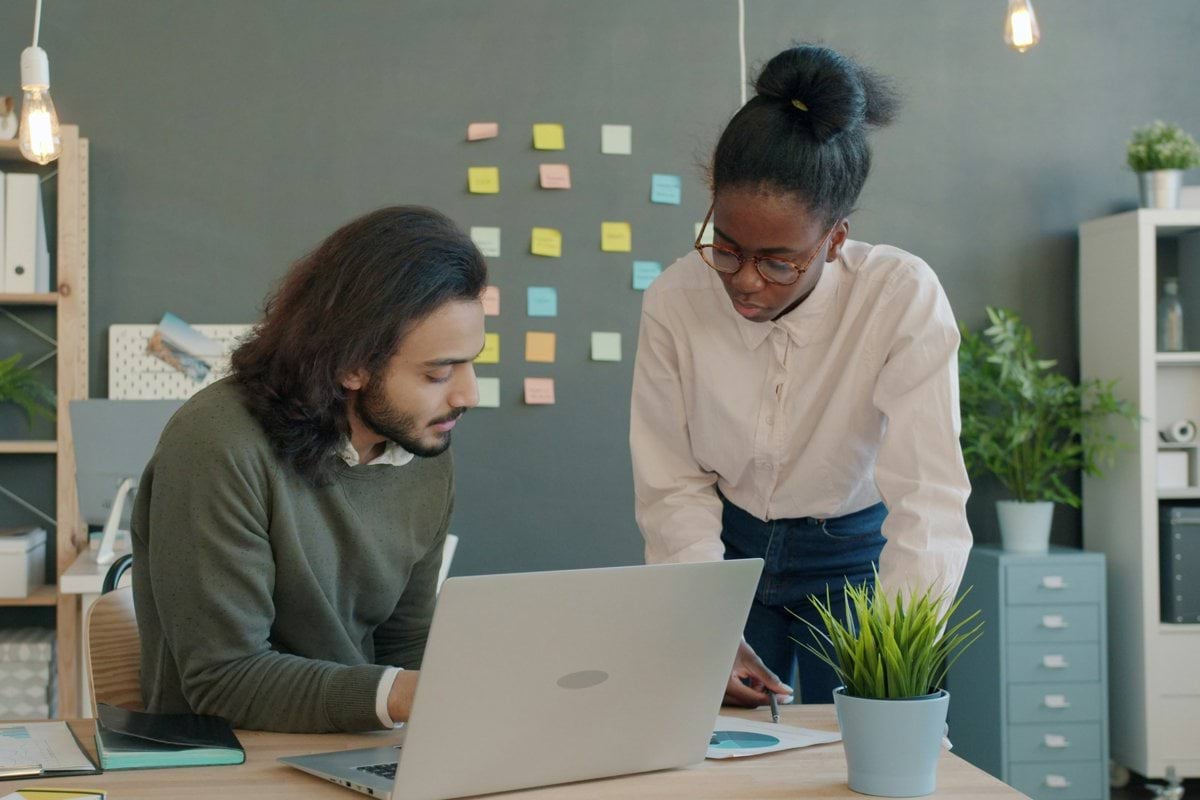 Two colleagues collaborating on a project at a desk.