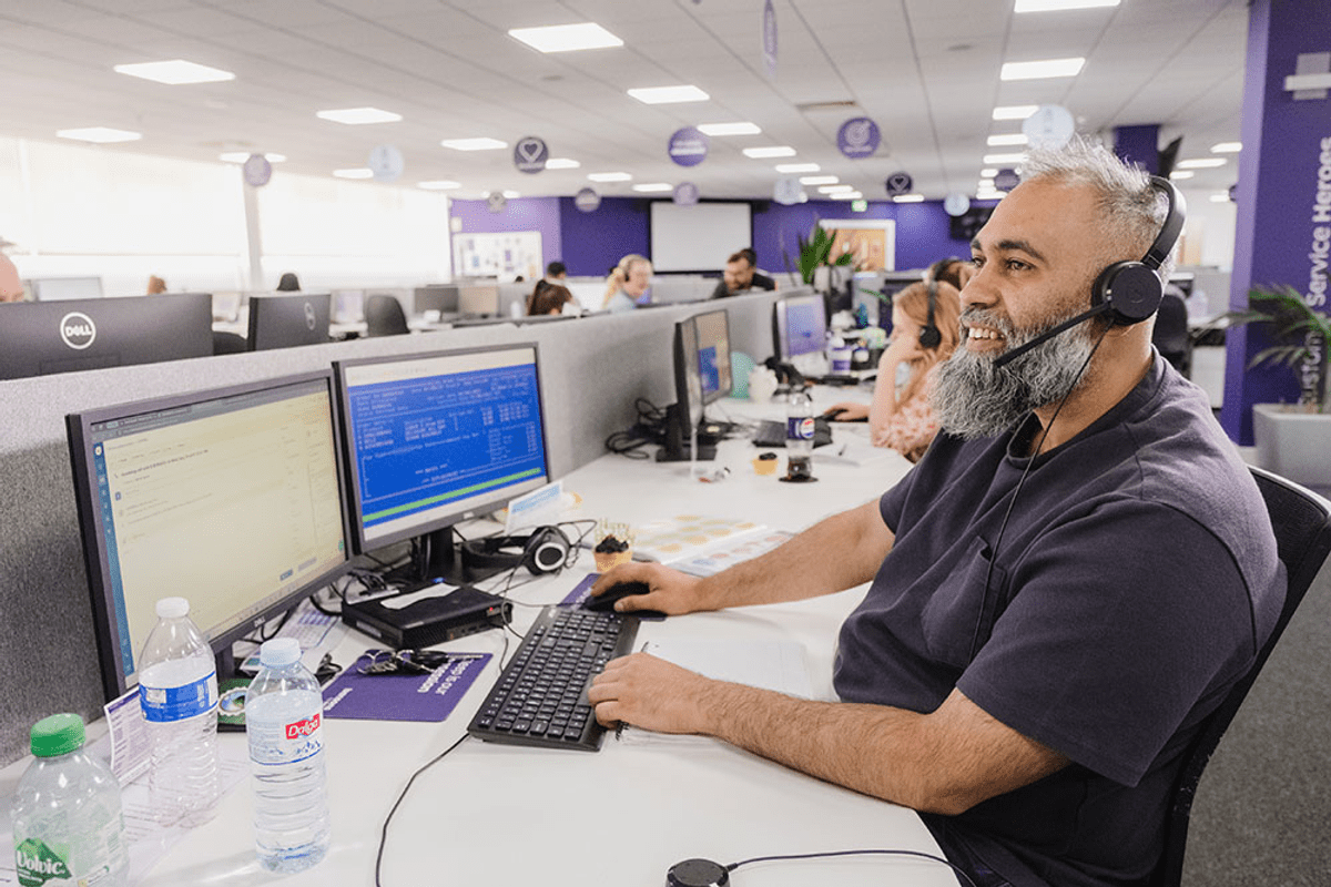 Man smiling on a call with a headset on