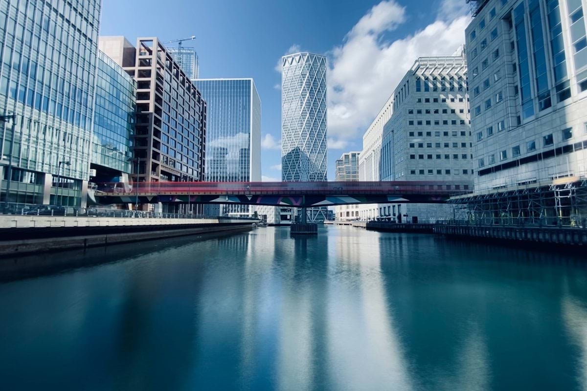 white and blue high rise buildings near body of water under blue sky during daytime
