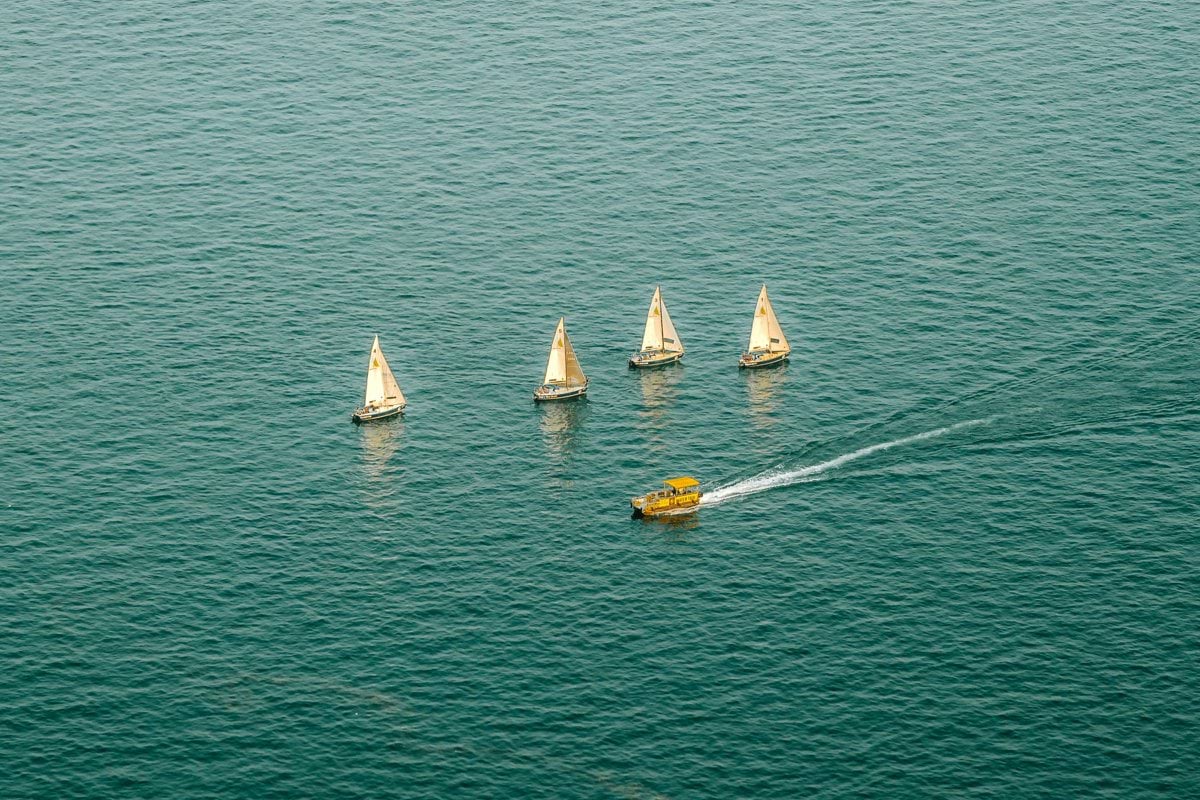 Four sailboats and a speedboat on the water