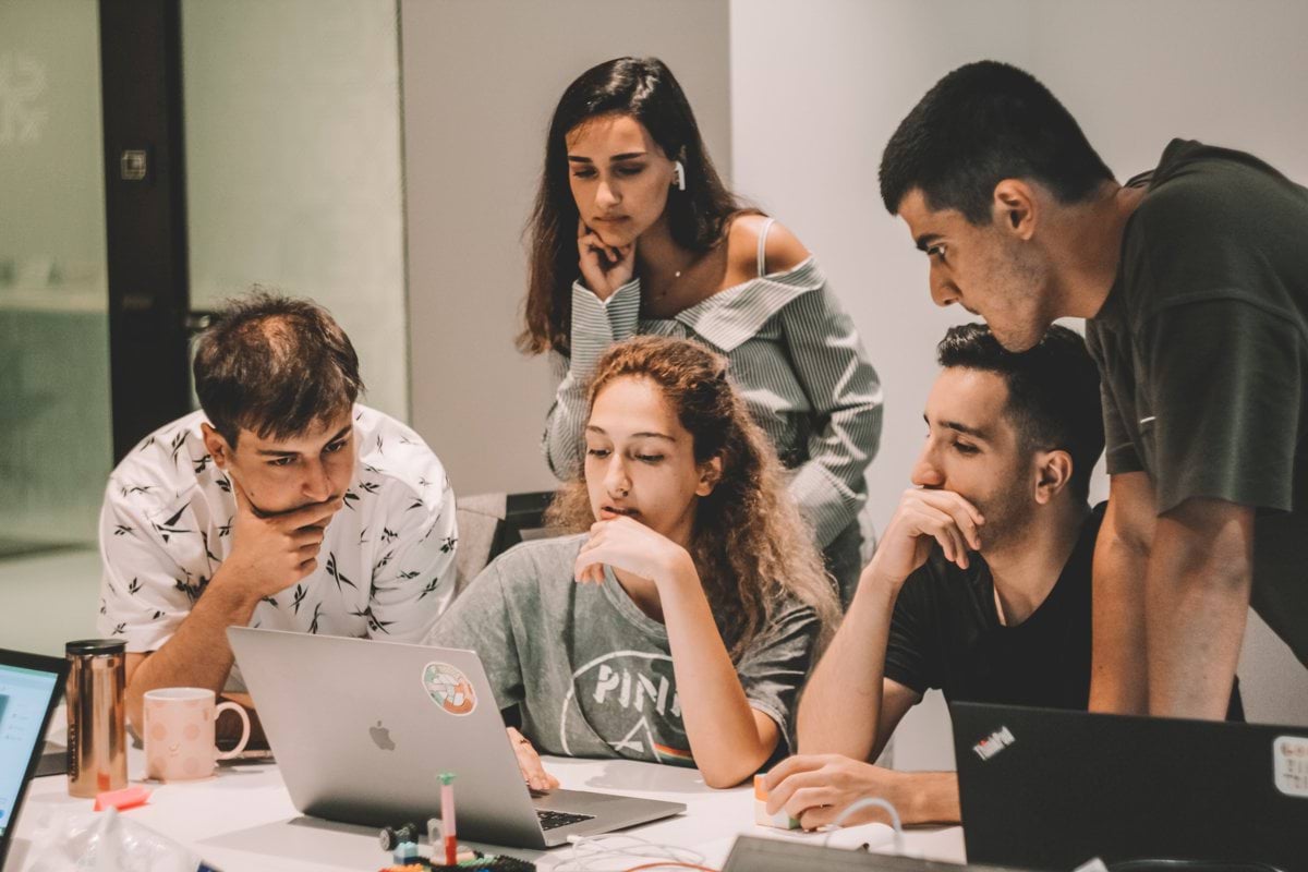 group of people sitting on chair in front of table with macbook