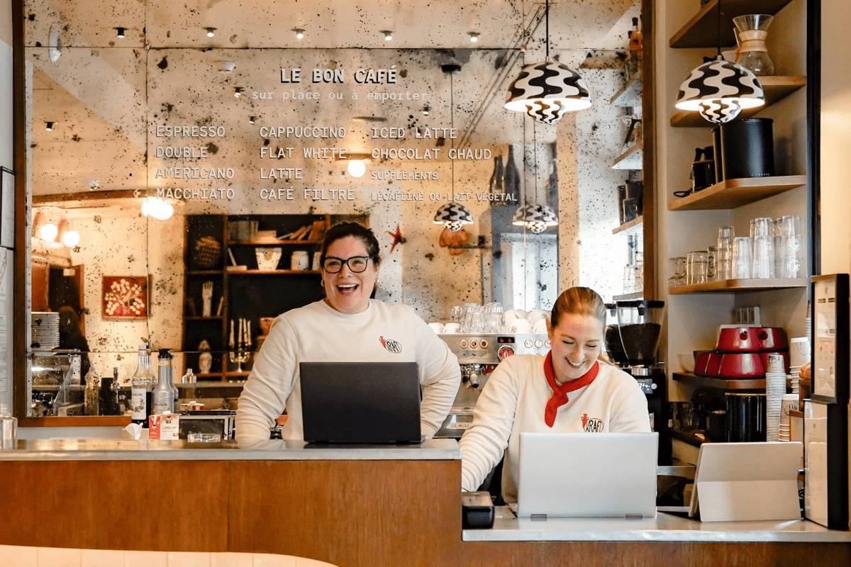 Deux employées souriantes derrière le comptoir d'un hôtel.