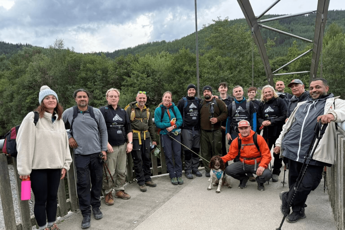 The HSL Compliance team participating in a group hiking challenge on a bridge, showcasing our company culture and commitment to outdoor team-building.