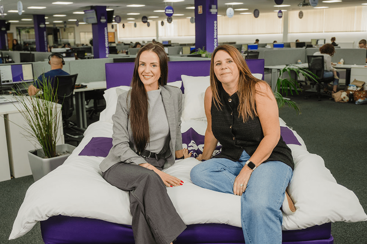 Two women sat on a bed in an office