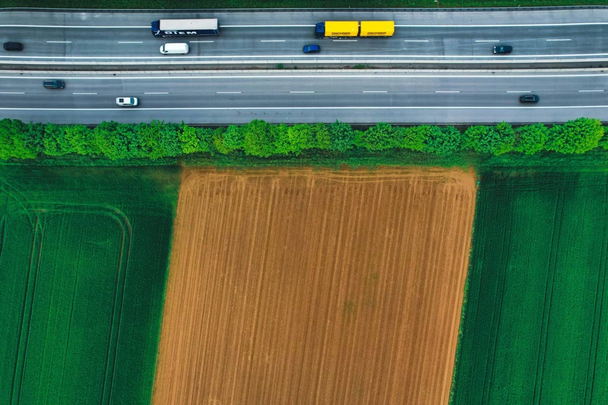 an aerial view of a highway and a field