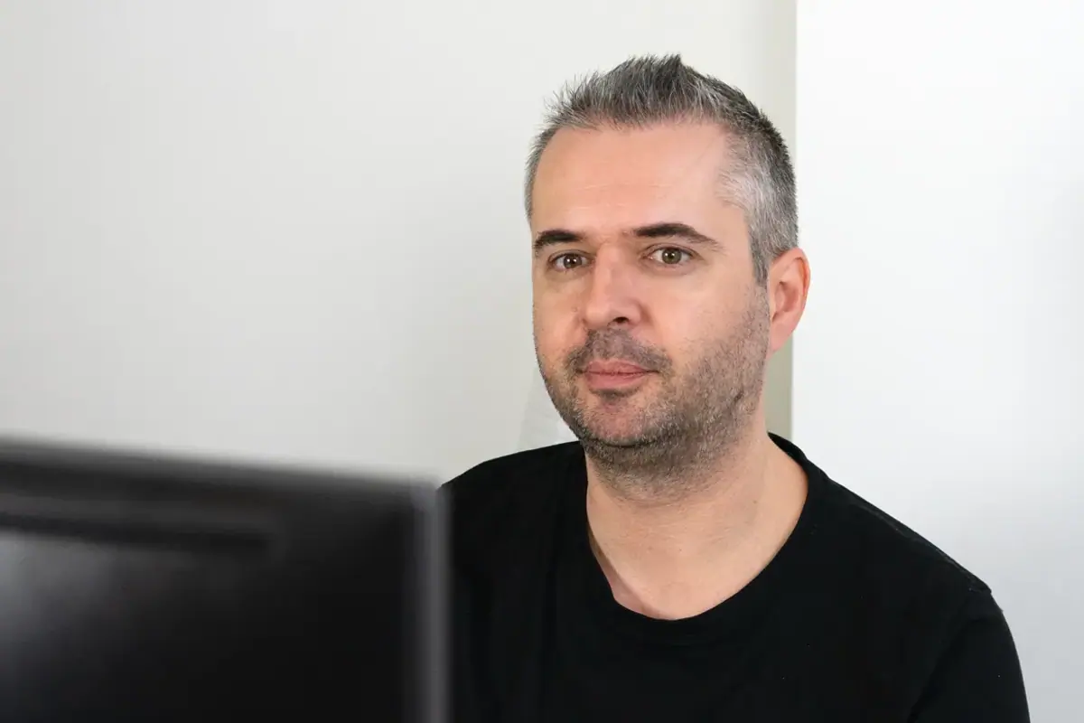 A colleague sitting at a desk and looking at a computer screen in an office.