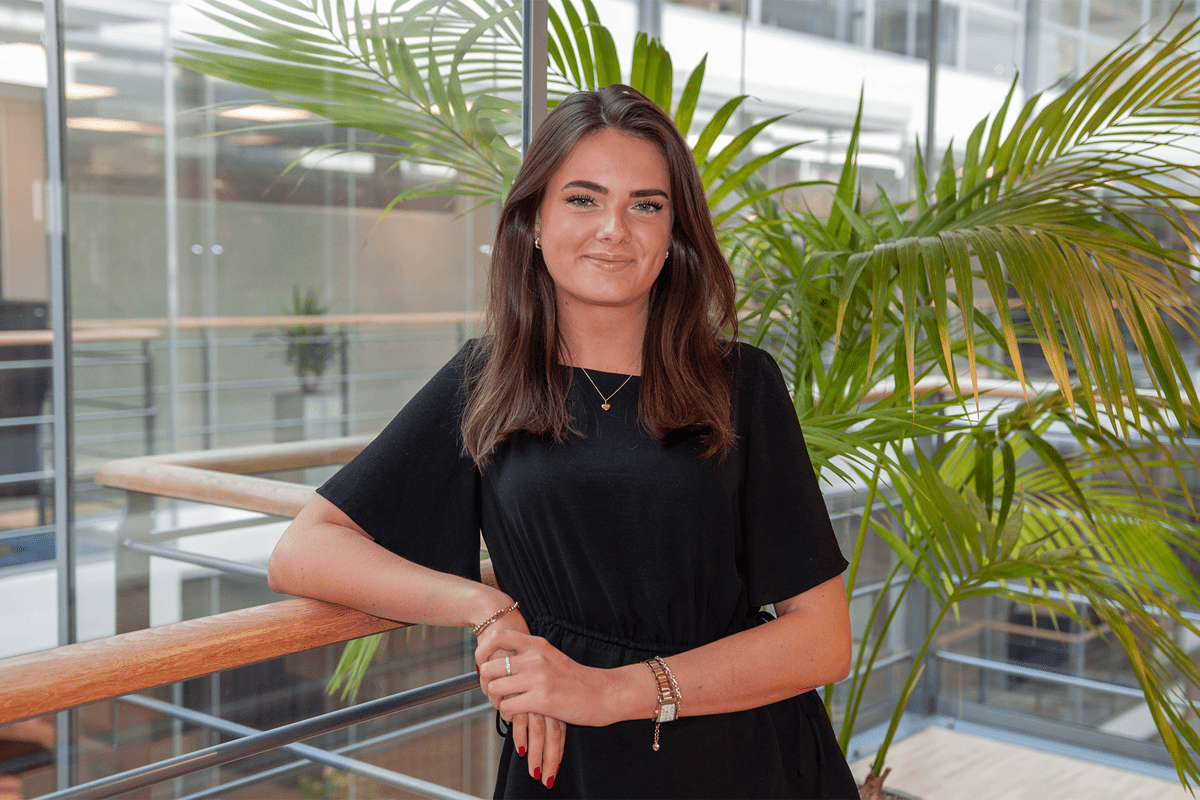 Kvinna står vid räcke i kontor.