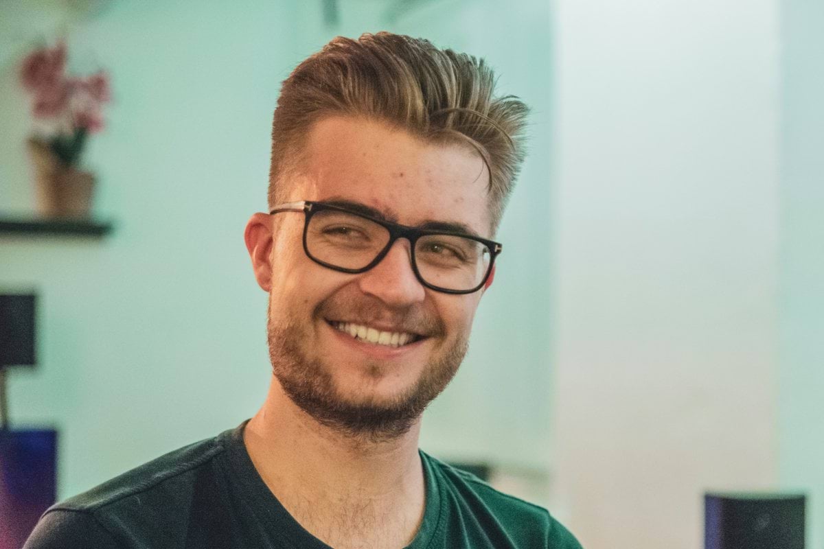 man wearing green crew-neck top and eyeglasses with black frames looking at side