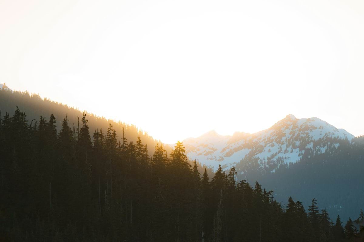the sun is shining on a mountain range
