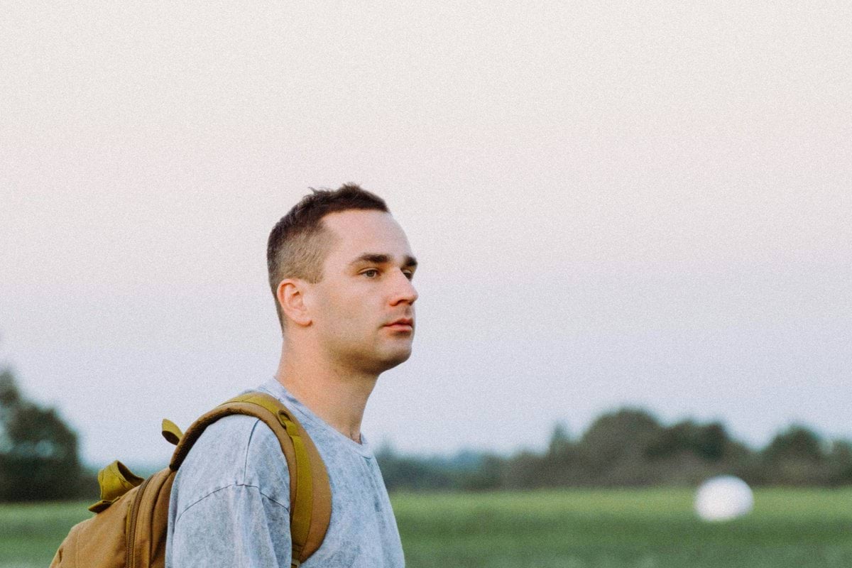 a man with a backpack standing in a field