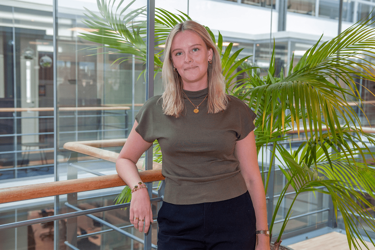 Kvinna står vid räcke med växter.