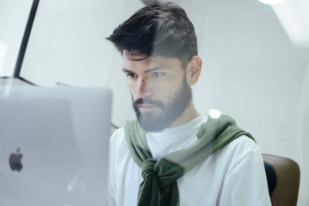 man facing MacBook Pro