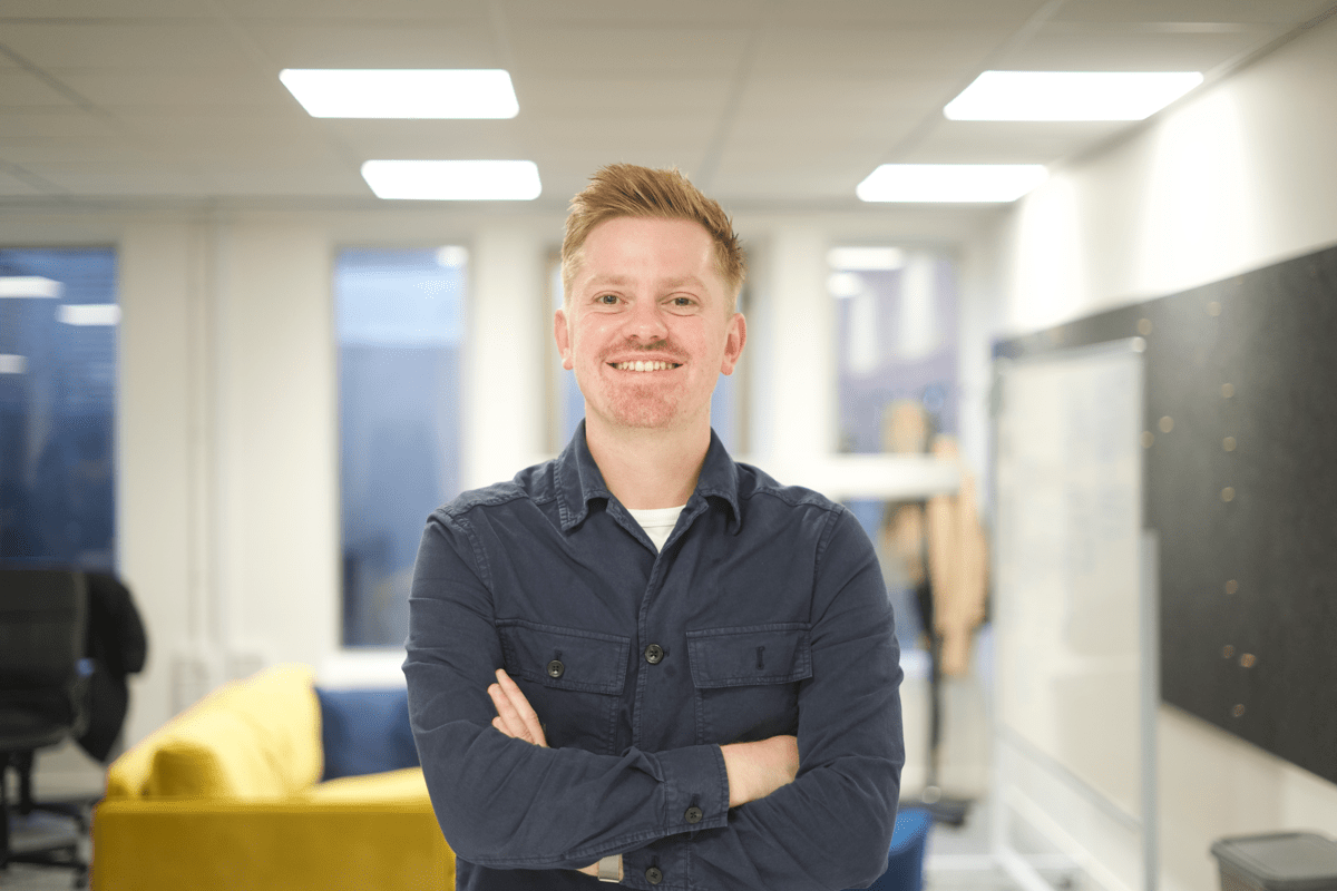 James, standing with his arms folded