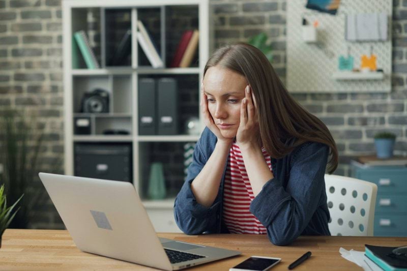a woman sitting at a table with a laptop in front of her