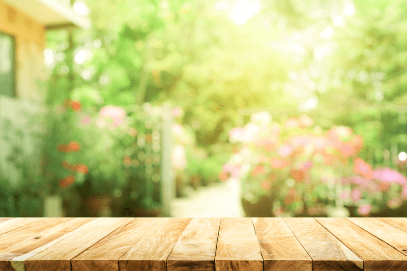 A blurred image of a garden and some wooden decking 