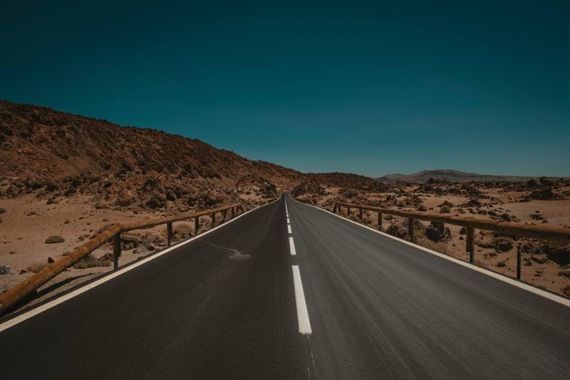 an empty road in the middle of a desert