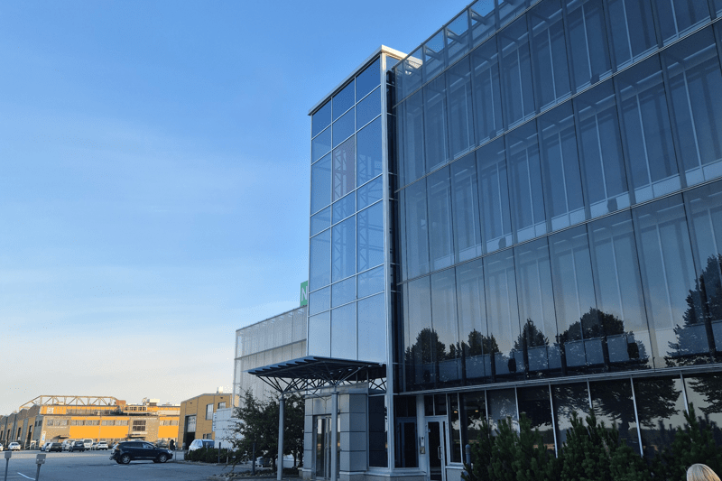 Nordec's big office building in Peräseinäjoki with sunlight hitting theglass exterior