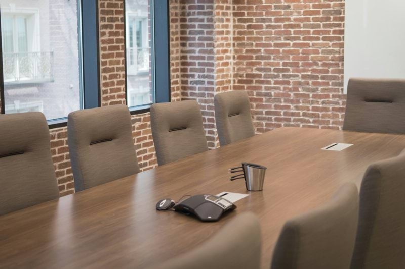 a conference room with a wooden table and chairs
