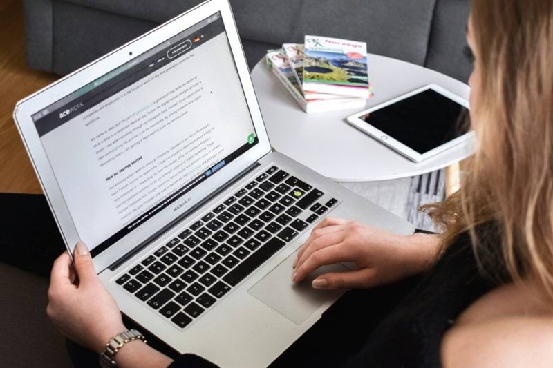 person using macbook air on lap