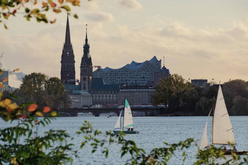 white sail boat on water near city buildings during daytime