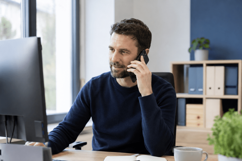Un collaborateur des fonctions support au téléphone depuis son bureau