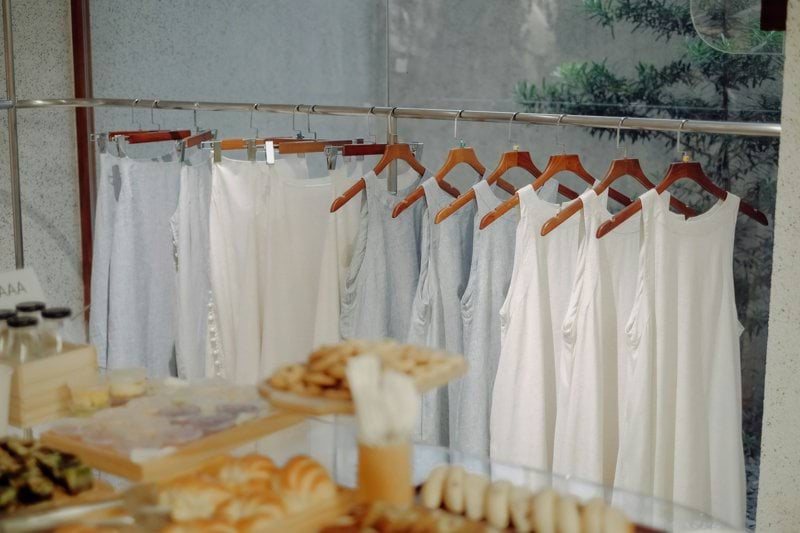 a rack of clothes hanging next to a window