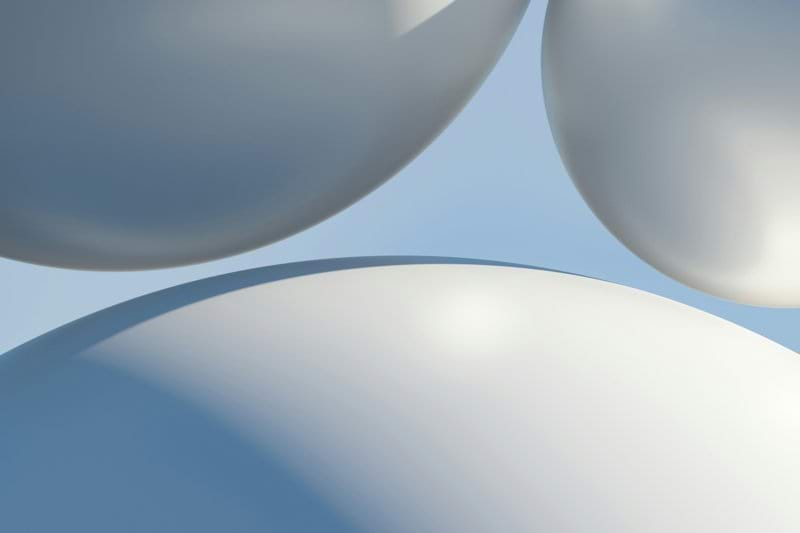 a bunch of white balloons floating in the air