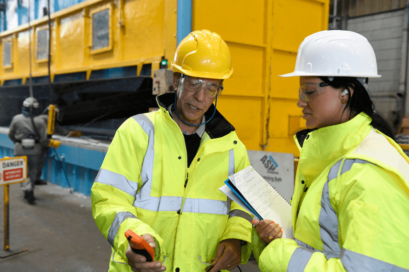 two operatives wearing PPE in a galvanizing plant