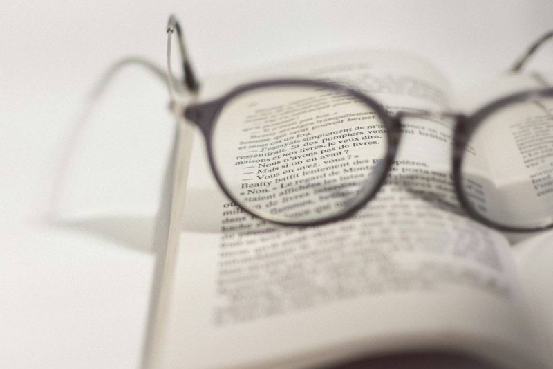 black framed eyeglasses on white book page