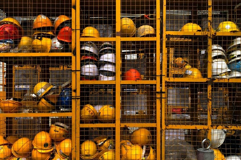 a rack filled with lots of yellow hard hats