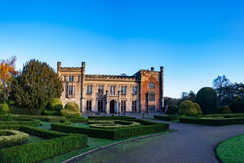 a large building surrounded by hedges and trees