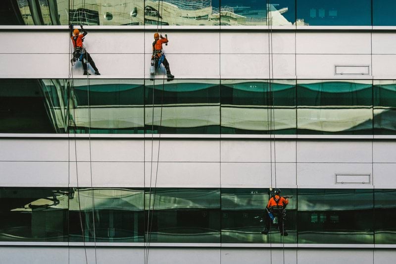 man cleaning white building