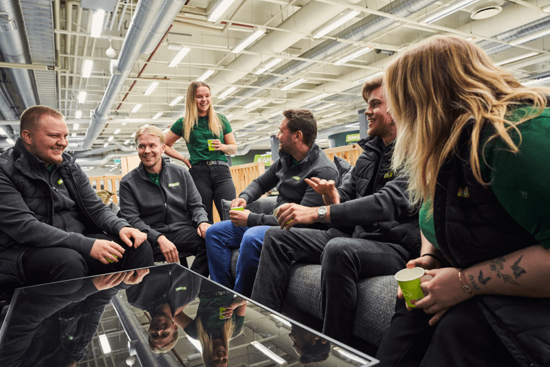 Kuvassa Kamuxin myyjiä keskustelemassa kahvin ääressä