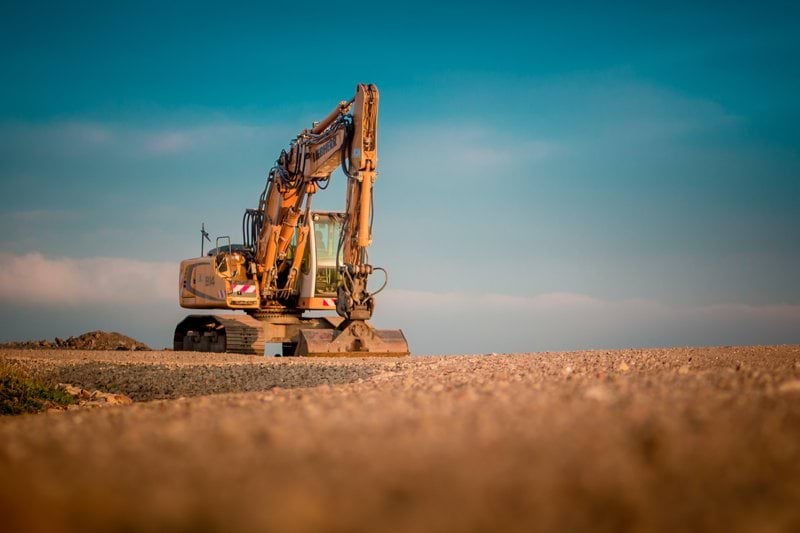 yellow and black excavator on brown sand during daytime