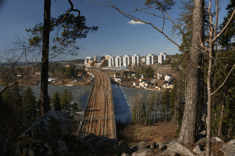 Vy över tågräls samt vita höghus i bakgrunden.