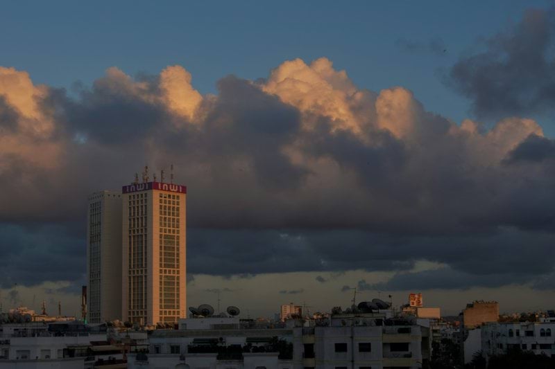 a tall building sitting under a cloudy sky