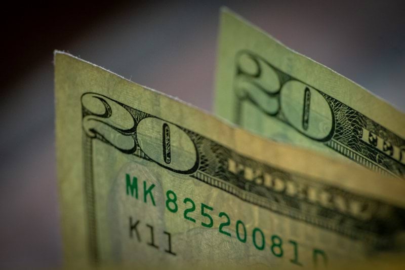 two stacks of twenty dollar bills sitting on top of each other