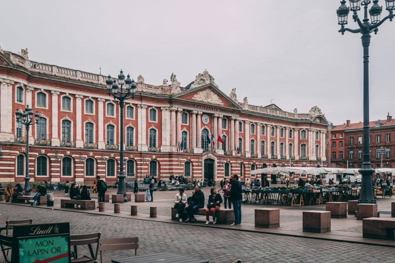 a large building with many windows with Capitole de Toulouse in the background