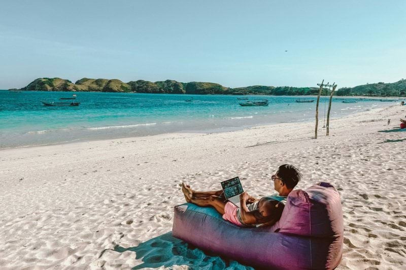 a man sitting on a bean bag on the beach