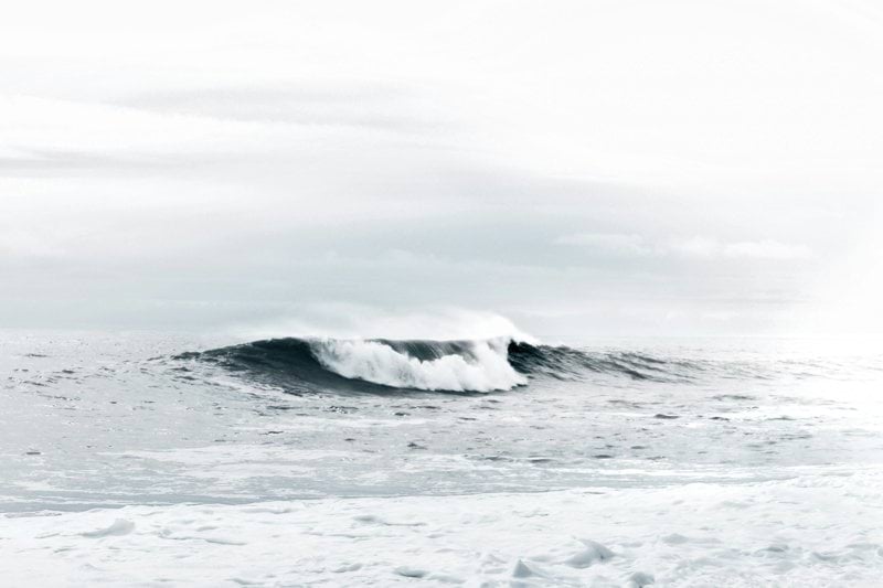 waves under cloudy sky during daytime