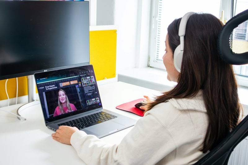 a woman sitting at a desk with a laptop and headphones