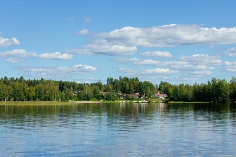 a body of water surrounded by trees and houses