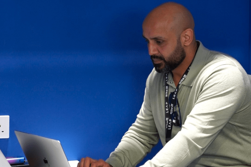 A man working on his own in a blue booth