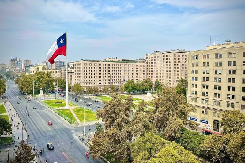 a flag flying in the air over a city street