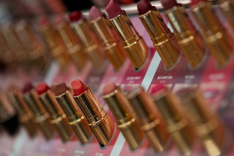 many lipsticks are lined up on a shelf