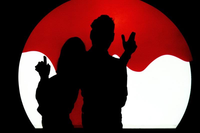 a man and a woman standing in front of a red sun