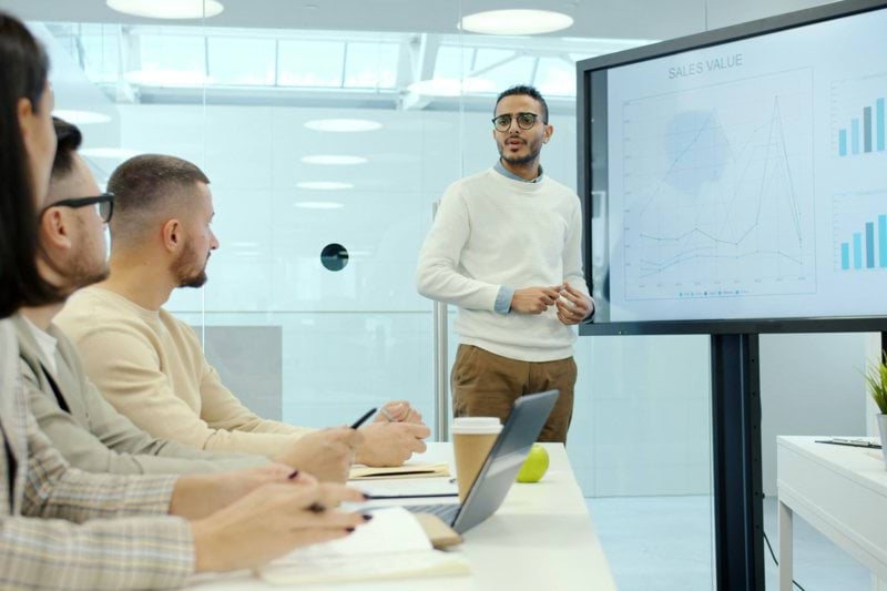 Man presenting charts to colleagues in a meeting